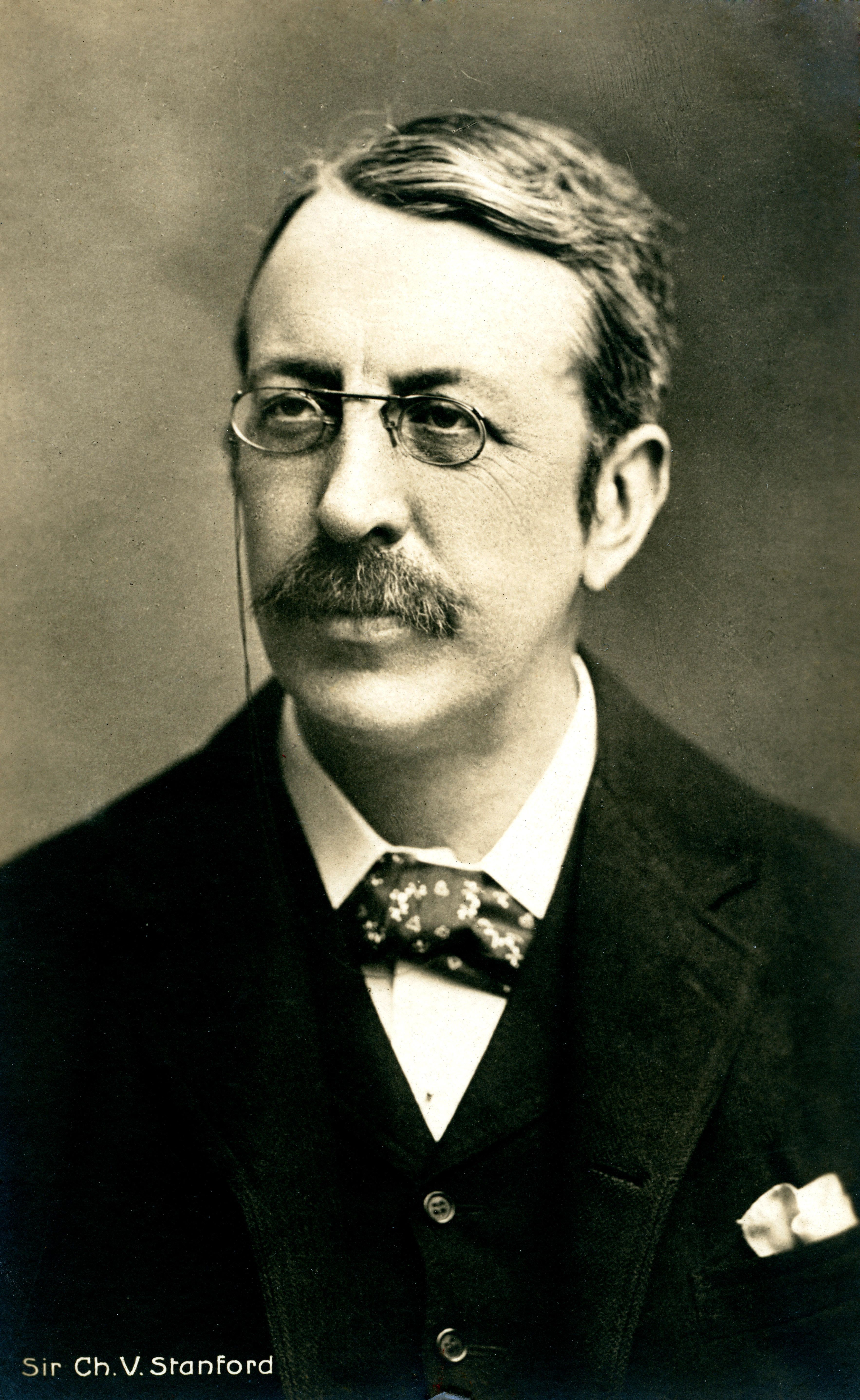 An old photograph of Charles Villiers Stanford, a man with a moustache and small glasses