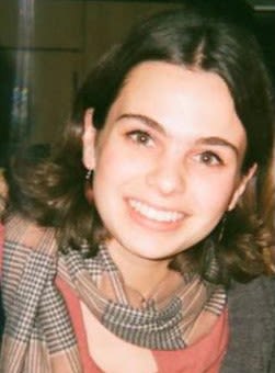 A girl with dark hair smiling