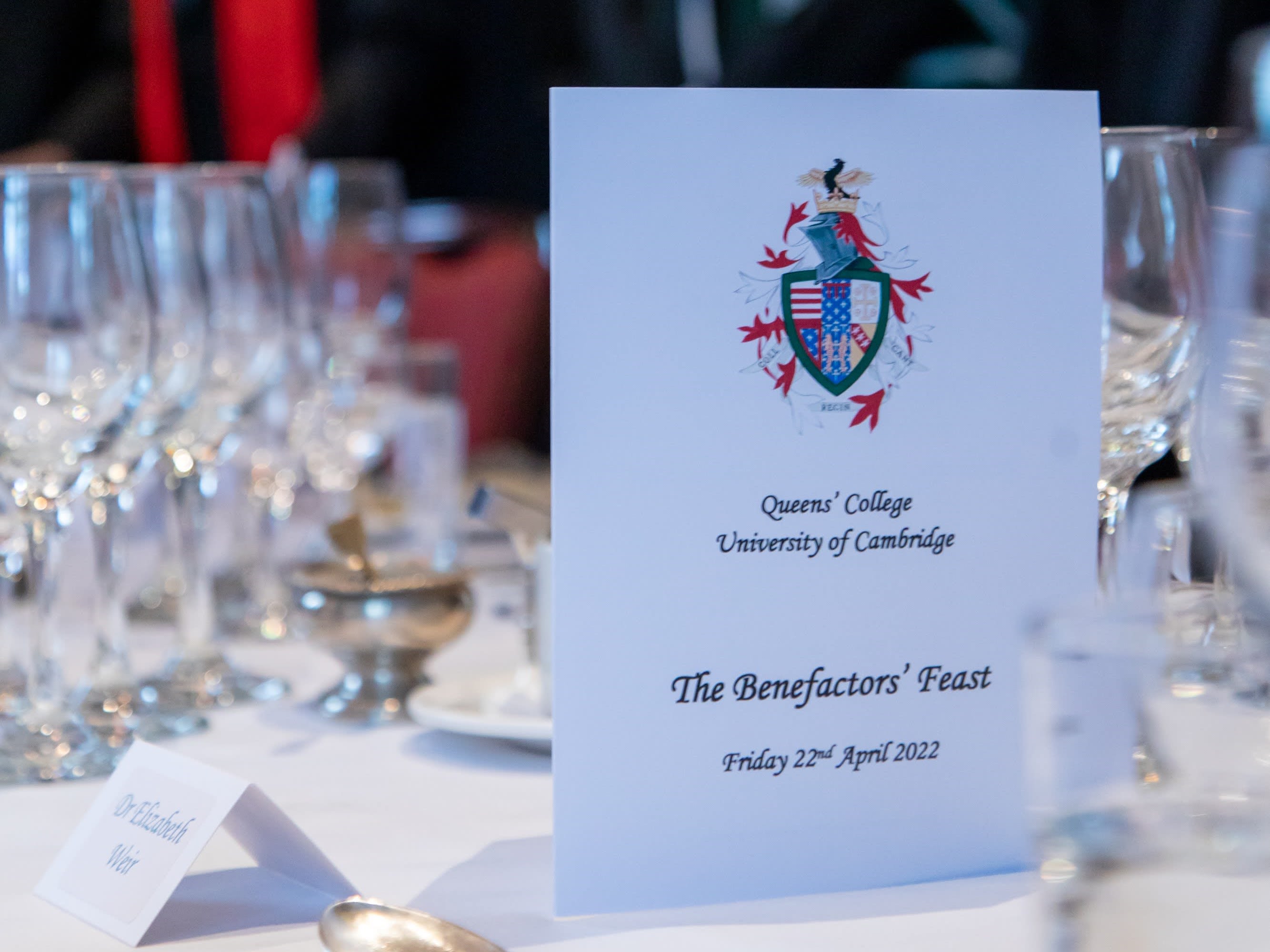 A menu on a table surrounded by wine glasses