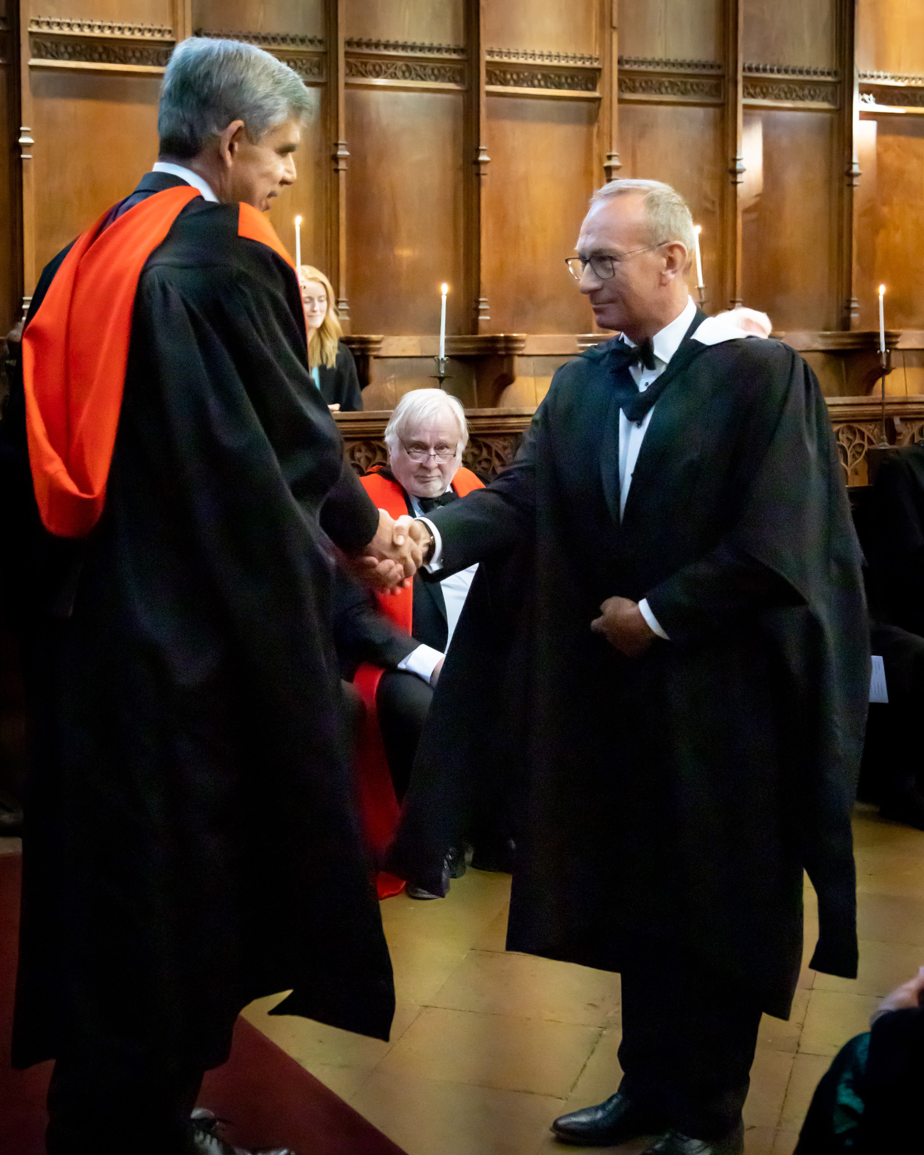 Man shaking hands with another man in Old Hall